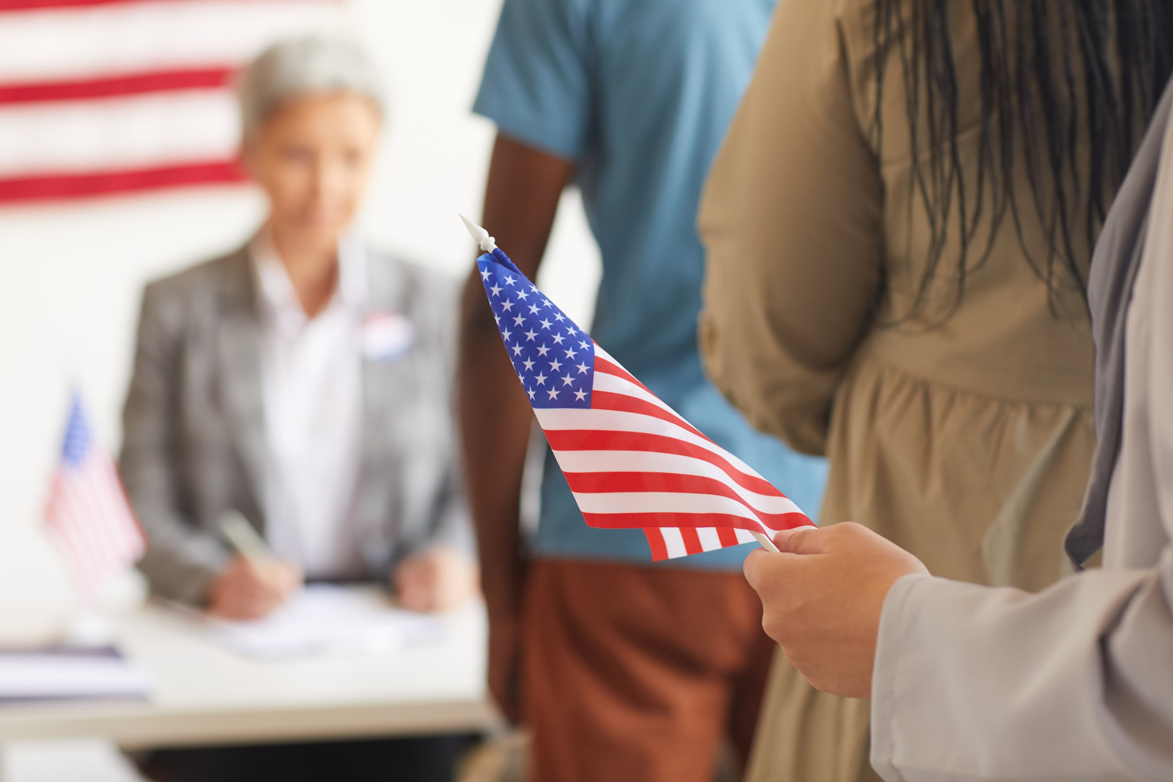 Person holding a small American flag at a citizenship-related setting